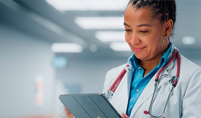 Healthcare professional working on a tablet.