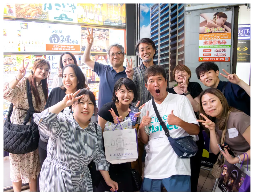 A cheerful group poses outdoors, smiling and making peace signs.