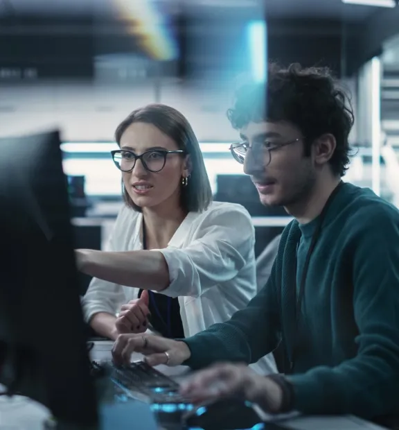 Colleagues working together on a company computer.