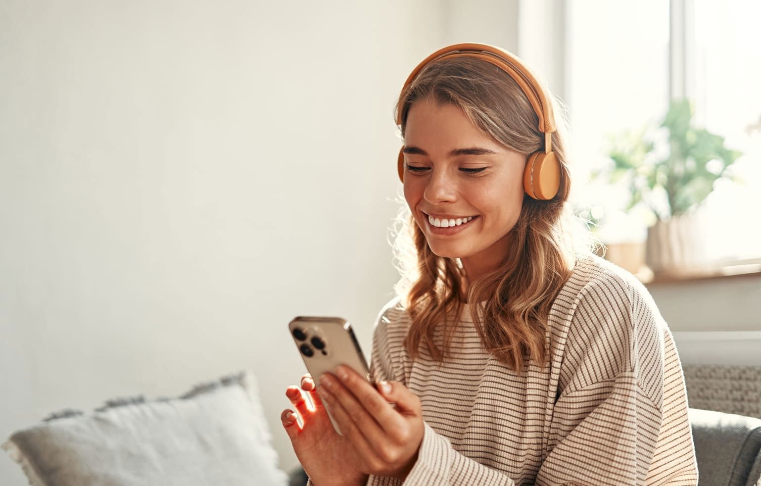 Smiling young woman enjoying music with headphones.