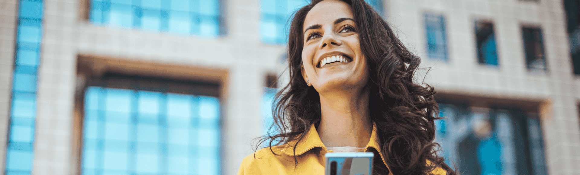 Smiling woman using a smartphone to illustrate B2B digital solutions for claims management.