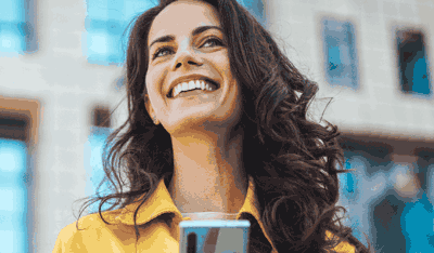 Smiling woman using a smartphone to illustrate B2B digital solutions for claims management.