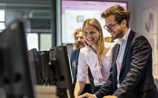 Colleagues working together on a company computer.