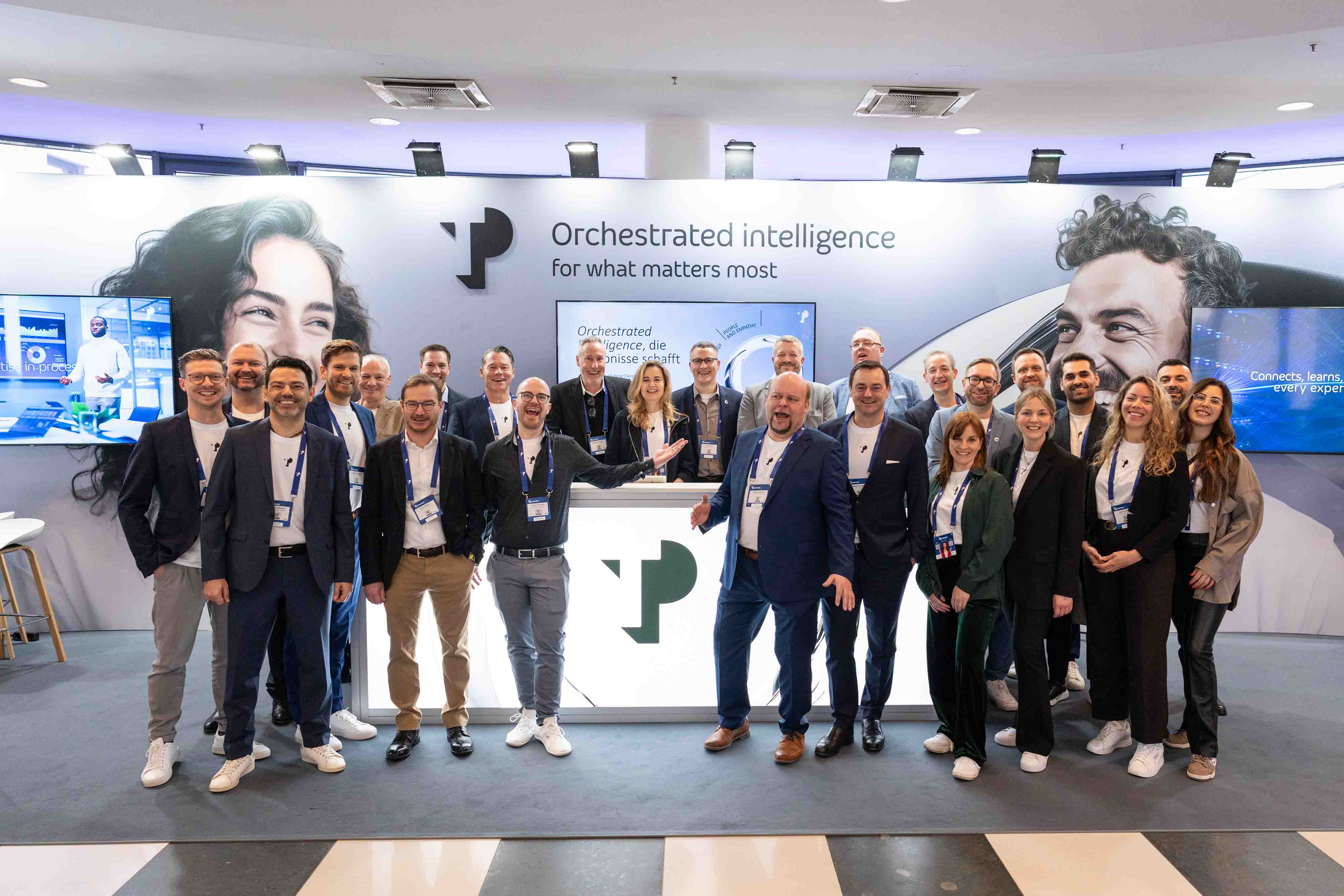 TP professionals posing in front of the company booth at an event.