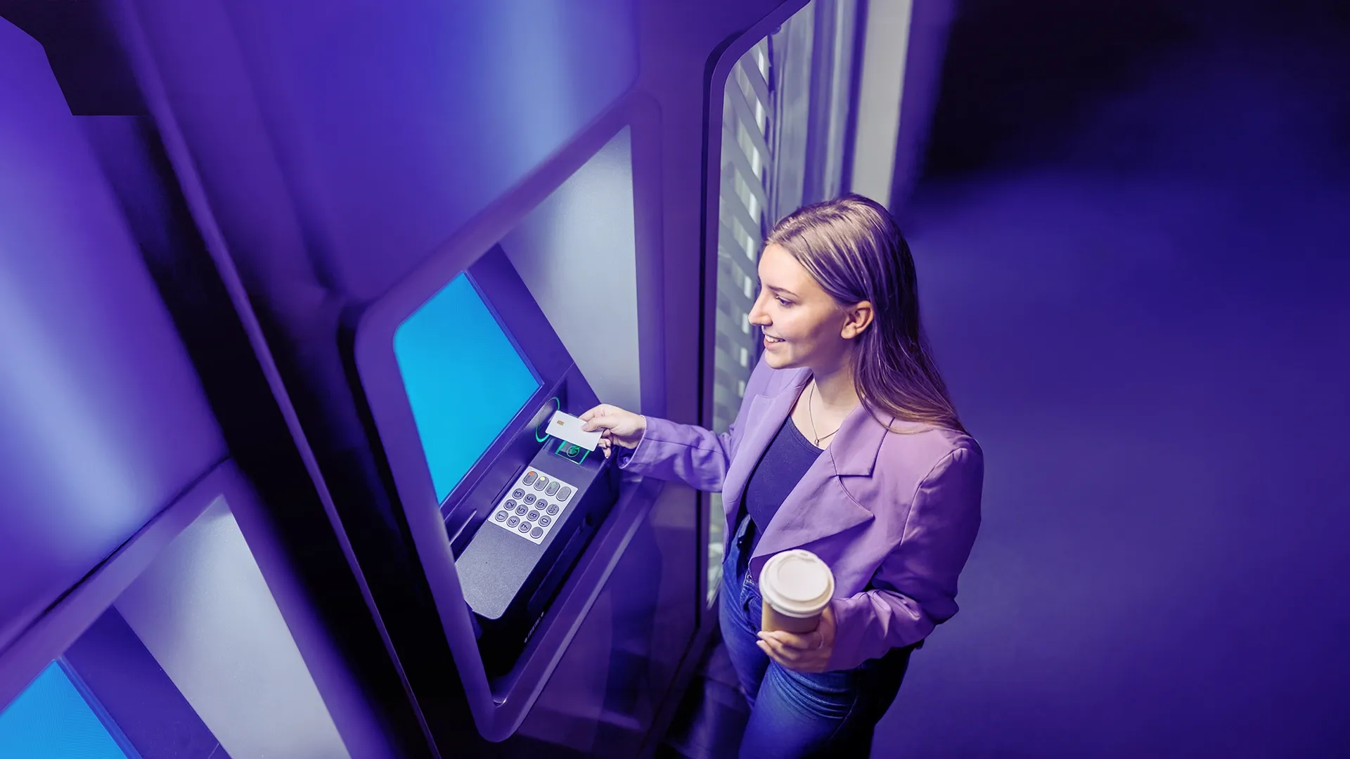 Young woman withdrawing cash from an ATM.