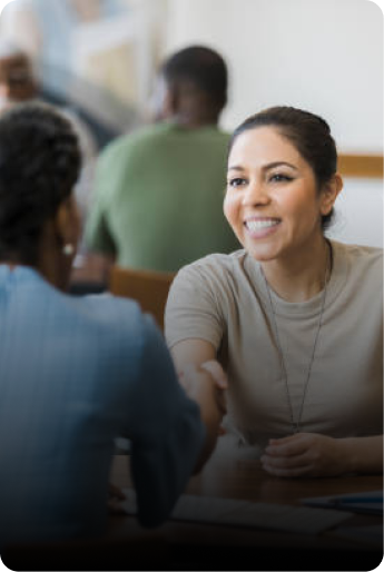 Two people shaking hands during a job interview conversation for a veterans employment opportunity.