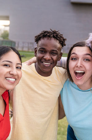 Group of friends hugging each other and smiling.