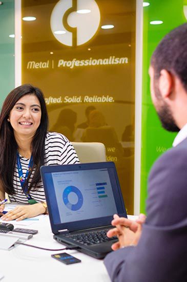 A laptop displays a graph while a woman smiles at a man in an office. text on the backdrop reads: "global | professionalism."