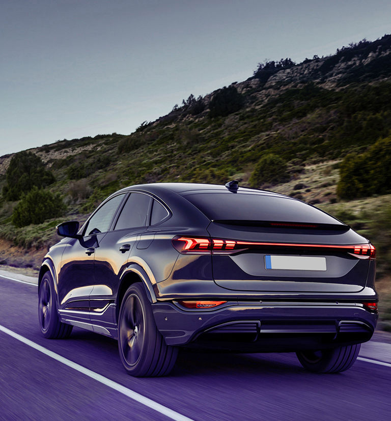 Black modern car driving on a road.