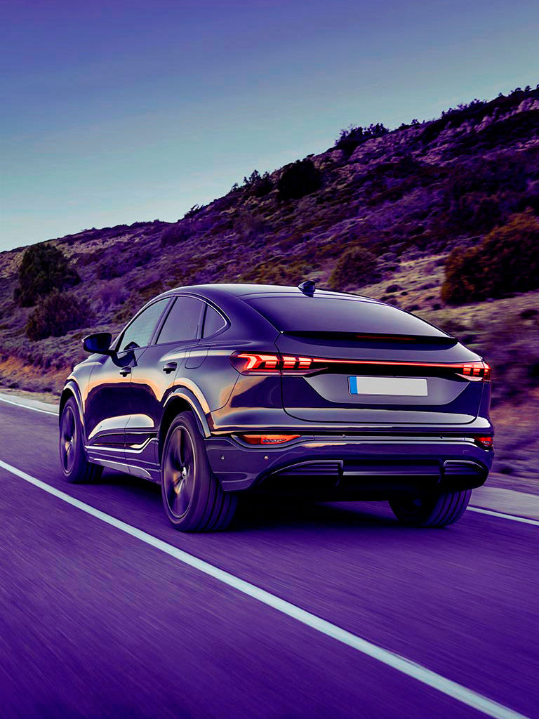 Black modern car driving on a road.