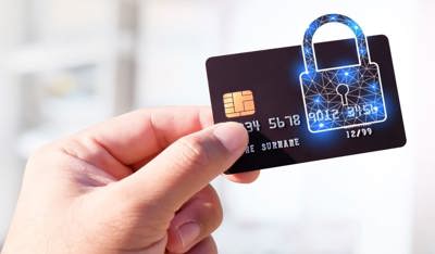 クレジットカードを南京錠で保護して持つ人、TPの銀行詐欺防止に関するブログを表しています。