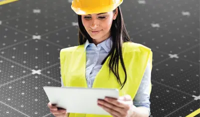 Professional wearing a helmet while reviewing a checklist on a clipboard.