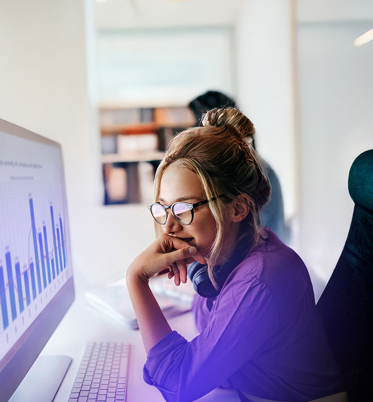 Employee analyzing performance charts on a desktop monitor at TP.