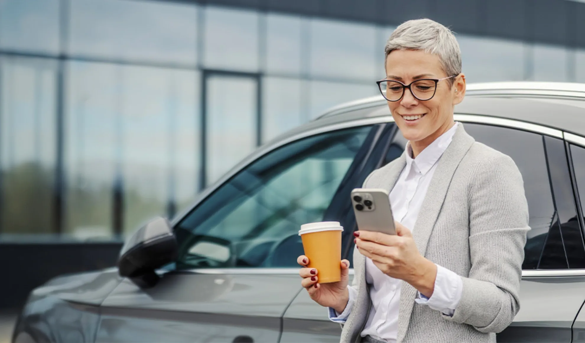 Relieved woman enjoying coffee by her car, supported by responsive automotive services.