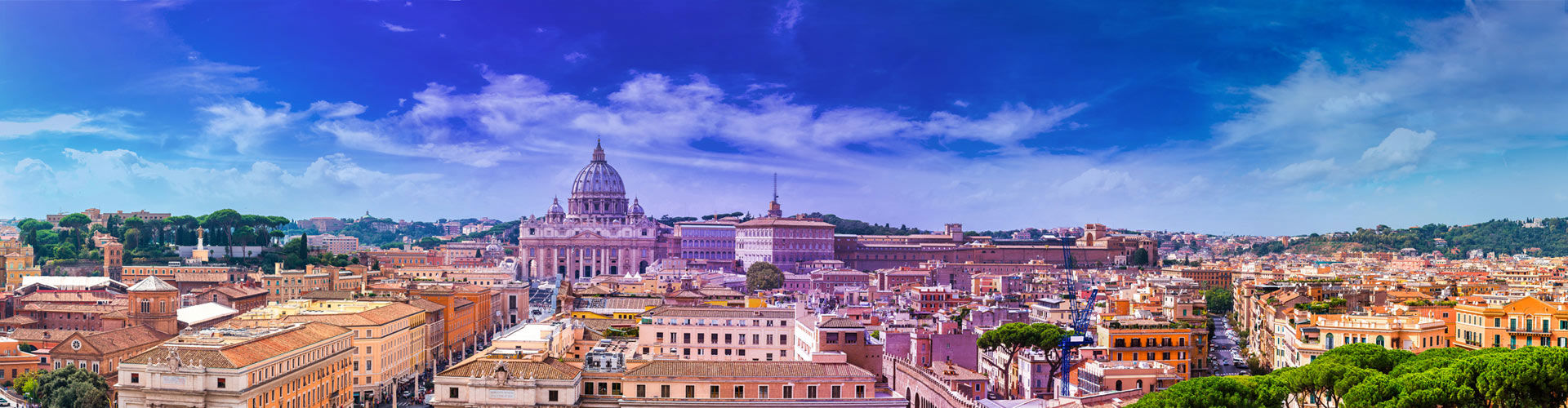Panoramic skyline of Rome, Italy, with St. Peter's Basilica dome at the center, under a vivid blue sky.