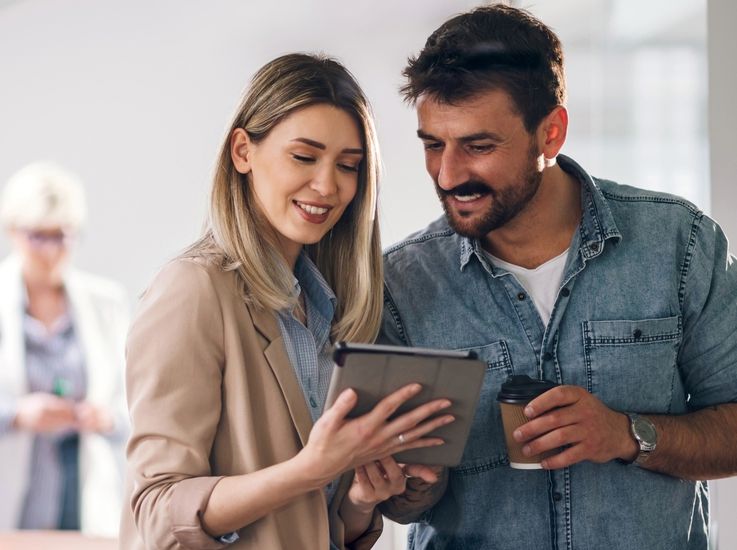Smiling couple looking at a tablet.