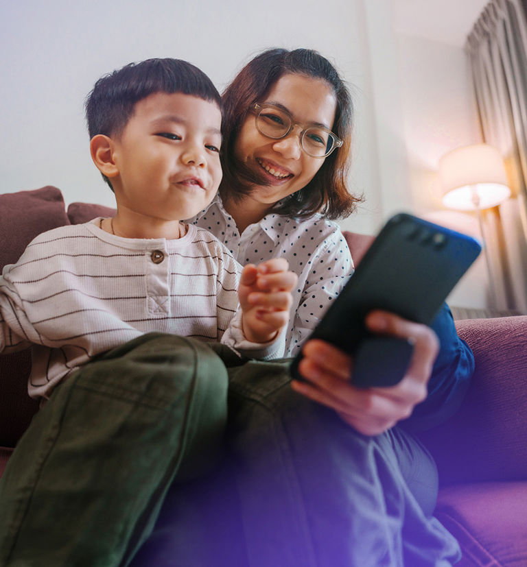 Mother and child using a digital device together, highlighting TP’s trust and safety services.