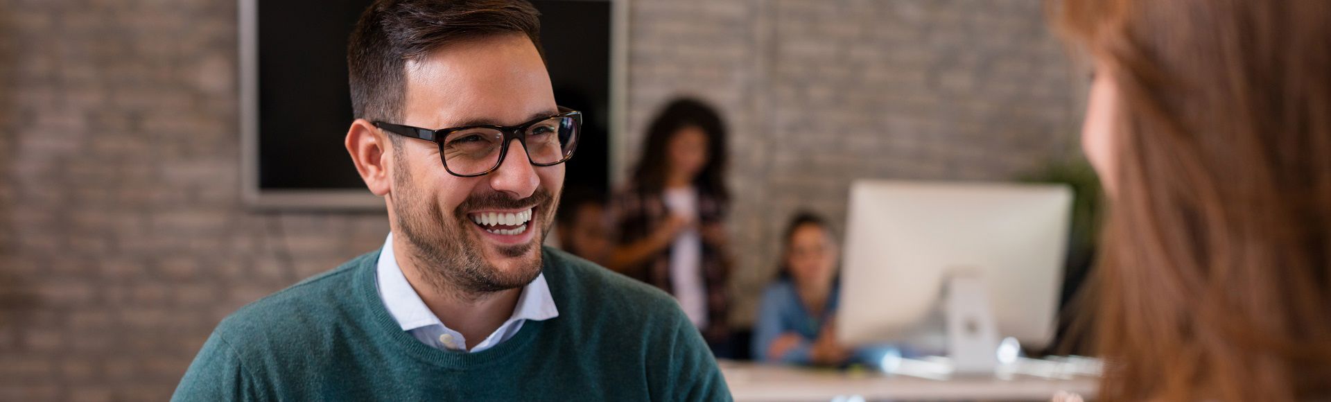 Smiling professional in a business setting, conveying confidence and approachability.