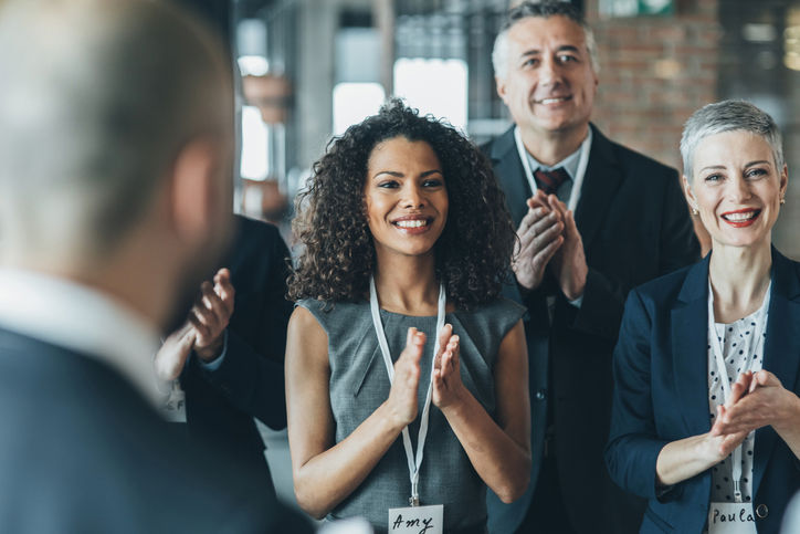 Professionals applauding during a business event.