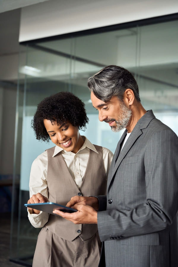Professionals gathered around a tablet discussing content.