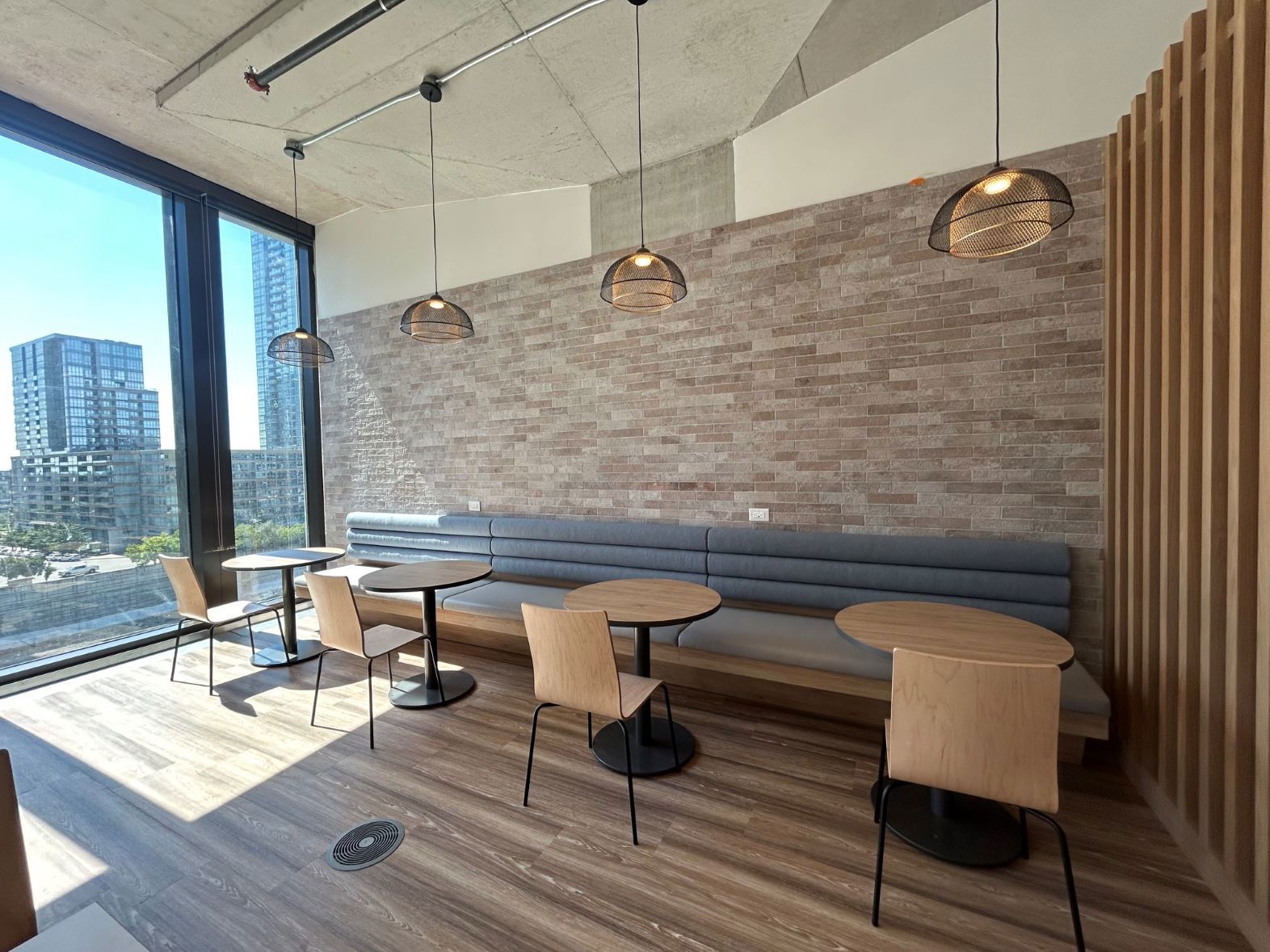 TP office lounge with desk, chairs, sofa, and city view.