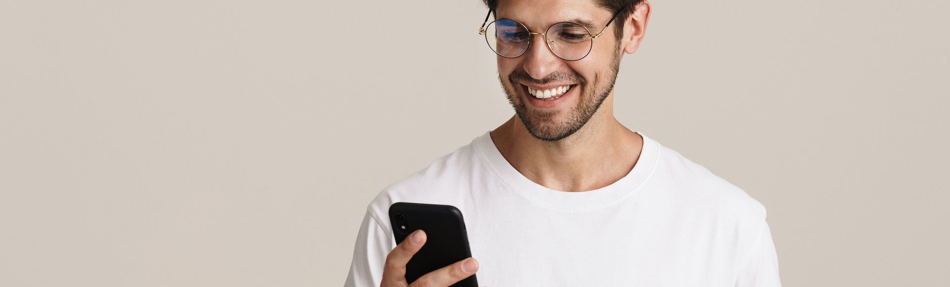 Smiling man looking at his smartphone screen.