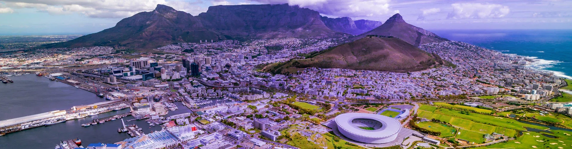 Aerial view of Cape Town, coastline, stadium, and Table Mountain.