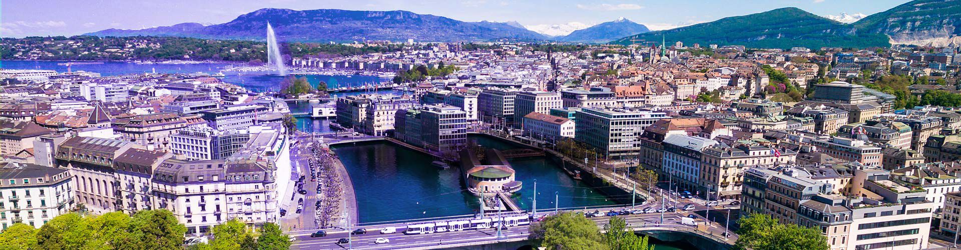Geneva cityscape with Lake Geneva, bridges, and the surrounding Alps.