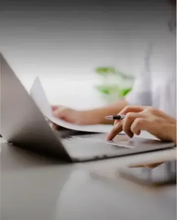 Professional working on a laptop in a focused setting.