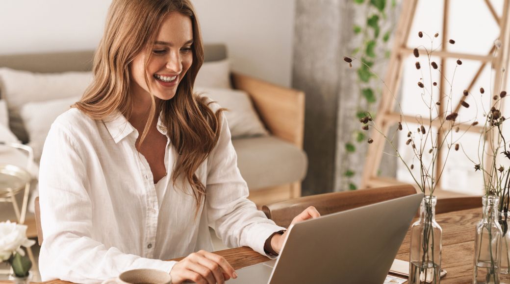 Smiling woman working on her laptop at home