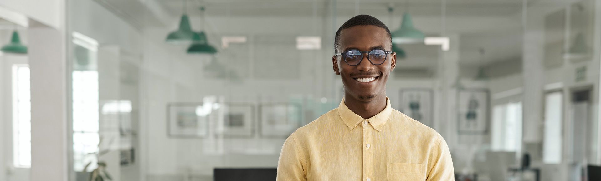 Smiling African man with glasses working in an office, highlighting TP’s innovation award.