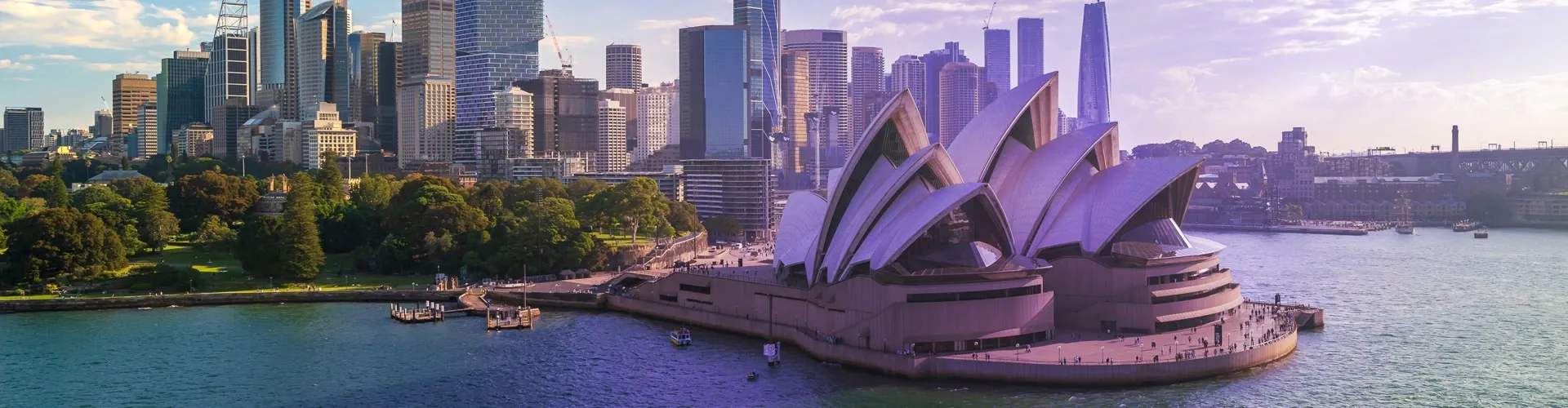 Panoramic view of Sydney, Australia, featuring the Sydney Opera House, Sydney Harbour, waterfront, and modern city skyline.