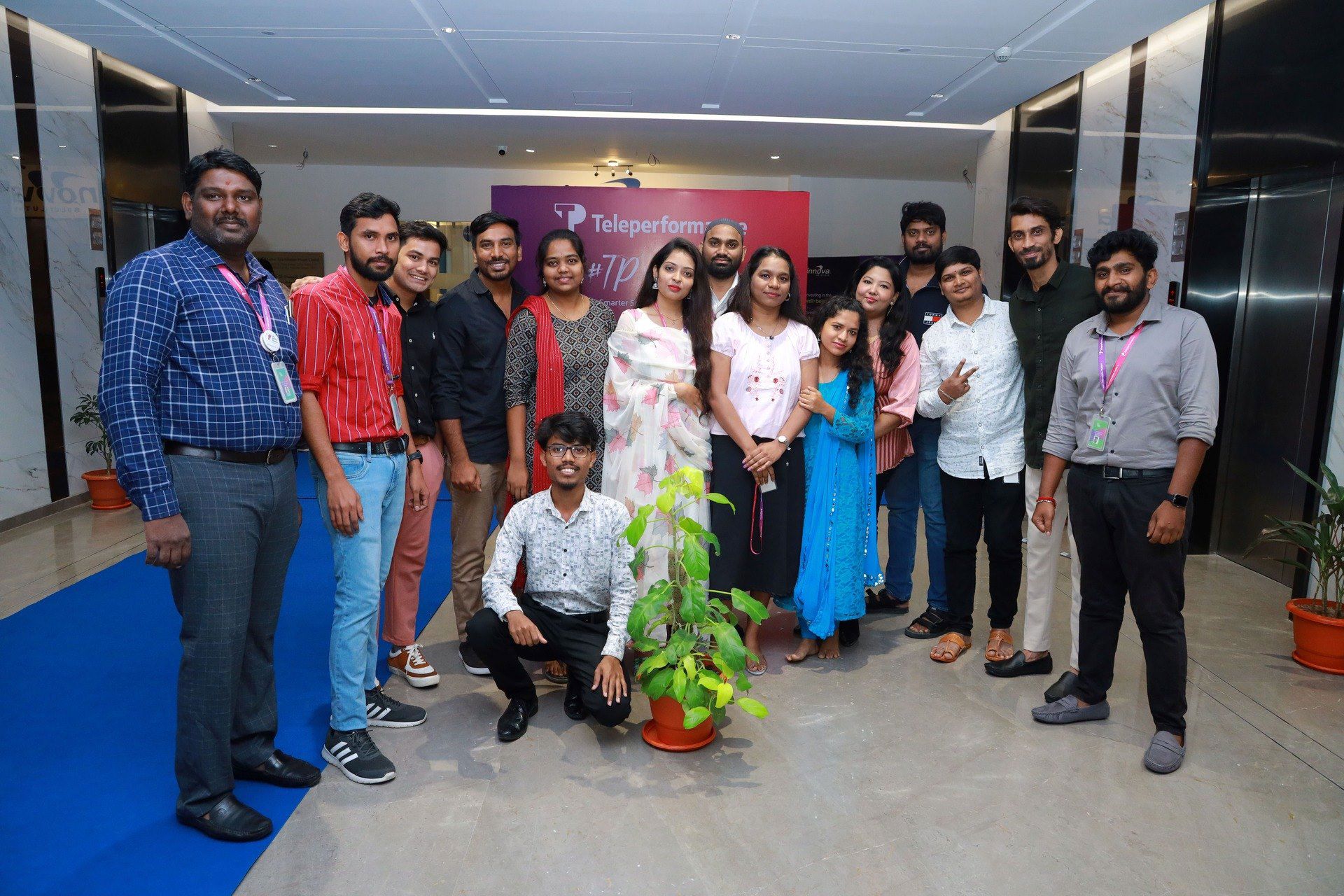 TP employees posing for a group photo during an indoor company event.