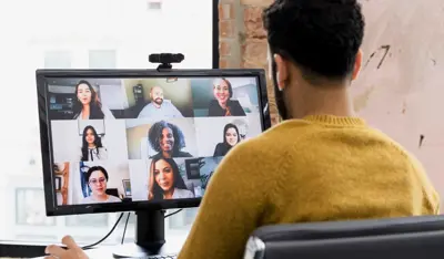 Professional joining a video call with colleagues from a home workspace.