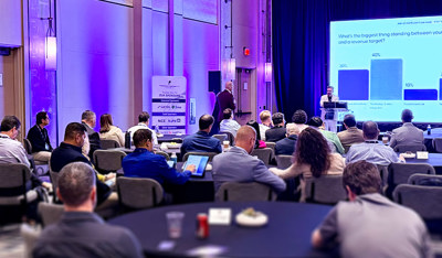 Attendees listen to a business presentation at a conference.