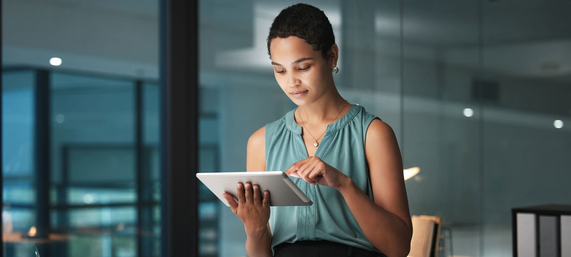 Woman using a tablet in a modern office environment.