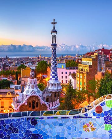 Vista de Barcelona con el monumento a Colón y los coloridos mosaicos de Gaudí en primer plano.