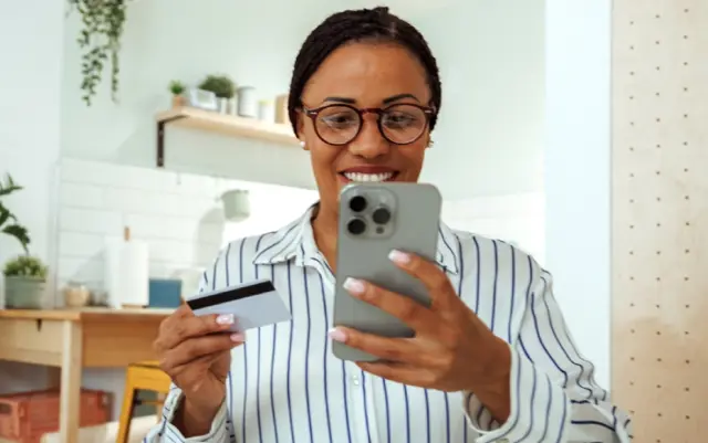 Woman managing her banking needs conveniently from home using a smartphone.