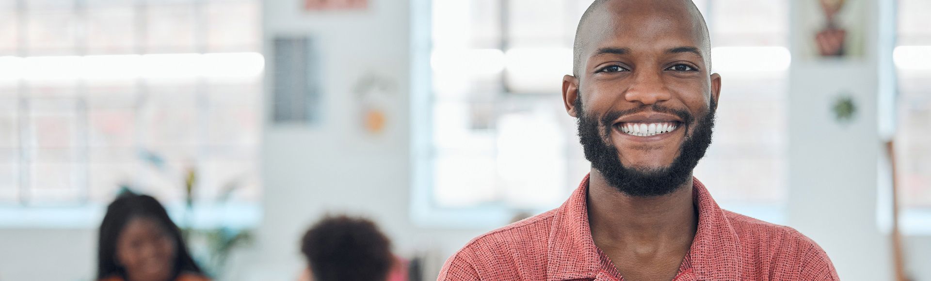 Smiling young African man, illustrating article on safeguarding Azure VMs with robust backups for security.