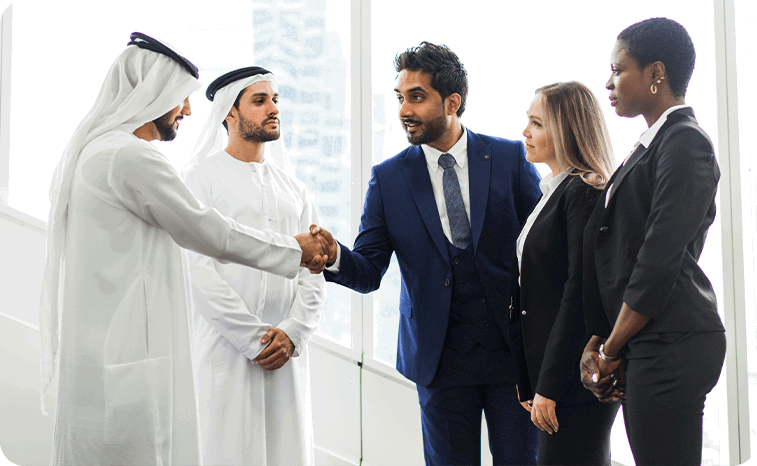 Cross-cultural business meeting with Middle Eastern and Western professionals in formal attire shaking hands in a modern office setting, symbolizing international collaboration and corporate partnership.