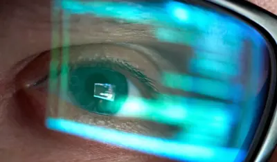 Close up of an eye with code reflected in glasses.