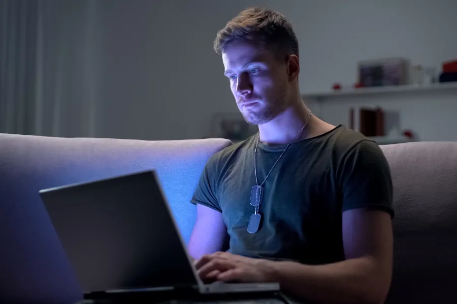 Military man connecting with family using a laptop.
