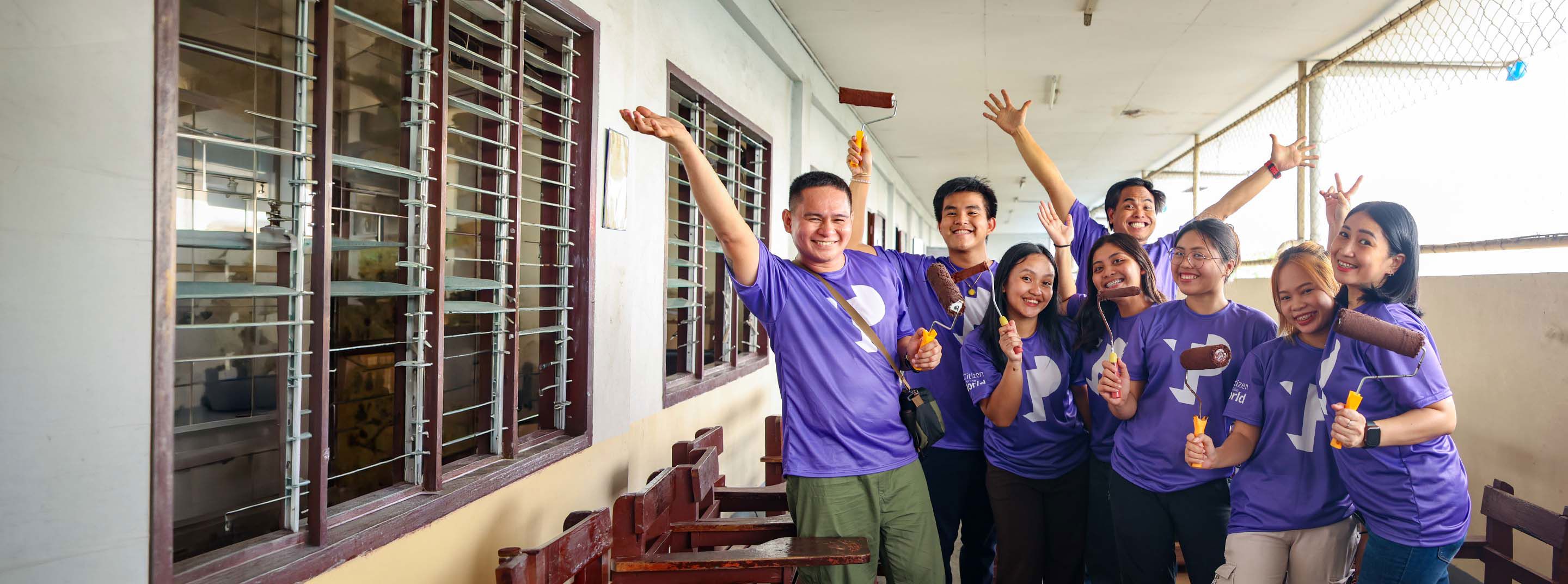 TP employees using brushes and paintbrushes during a community initiative.