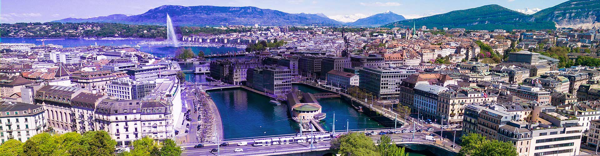 Geneva cityscape with Lake Geneva, bridges, and surrounding mountains.