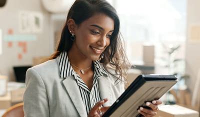 Smiling business woman working on her tablet.
