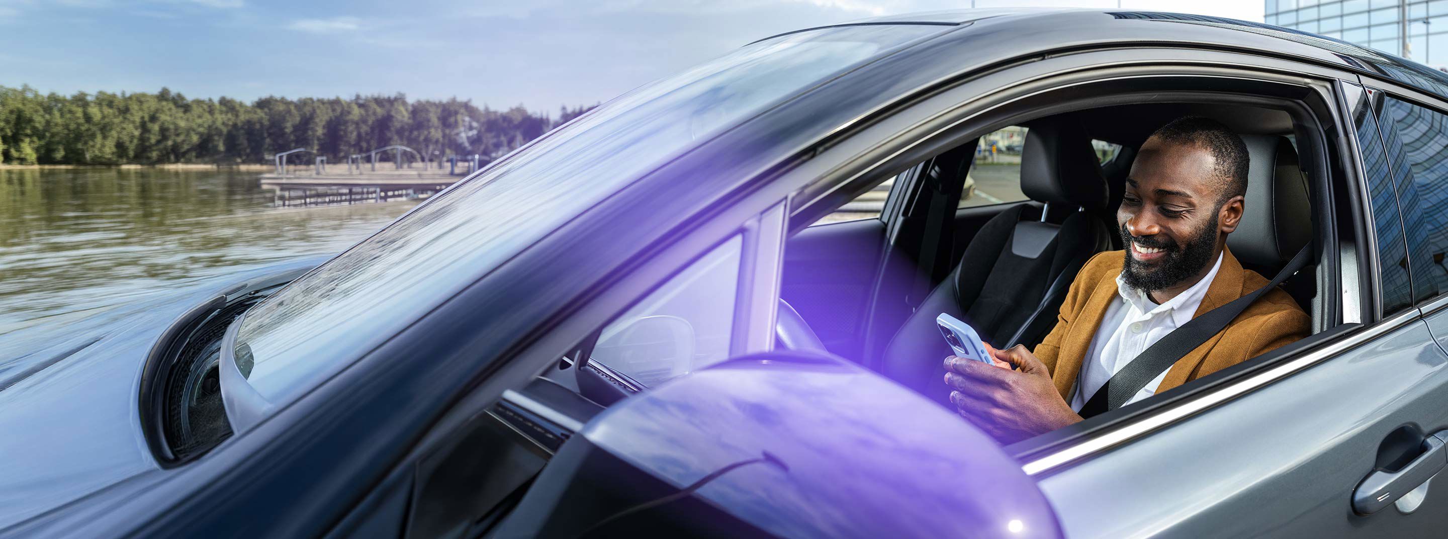 Man using a smartphone while seated in a car, representing TP’s customer experience services.