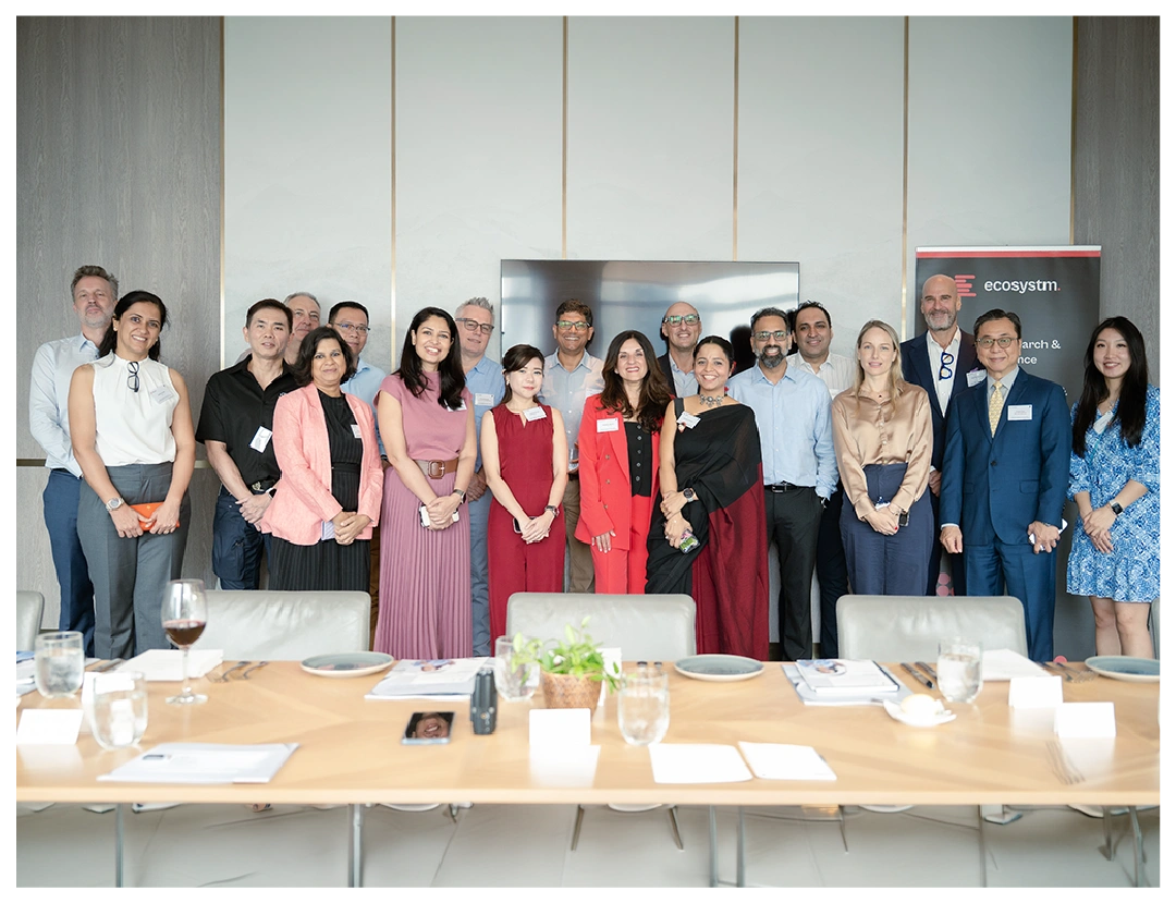 A diverse group of professionals poses for a conference photo indoors.