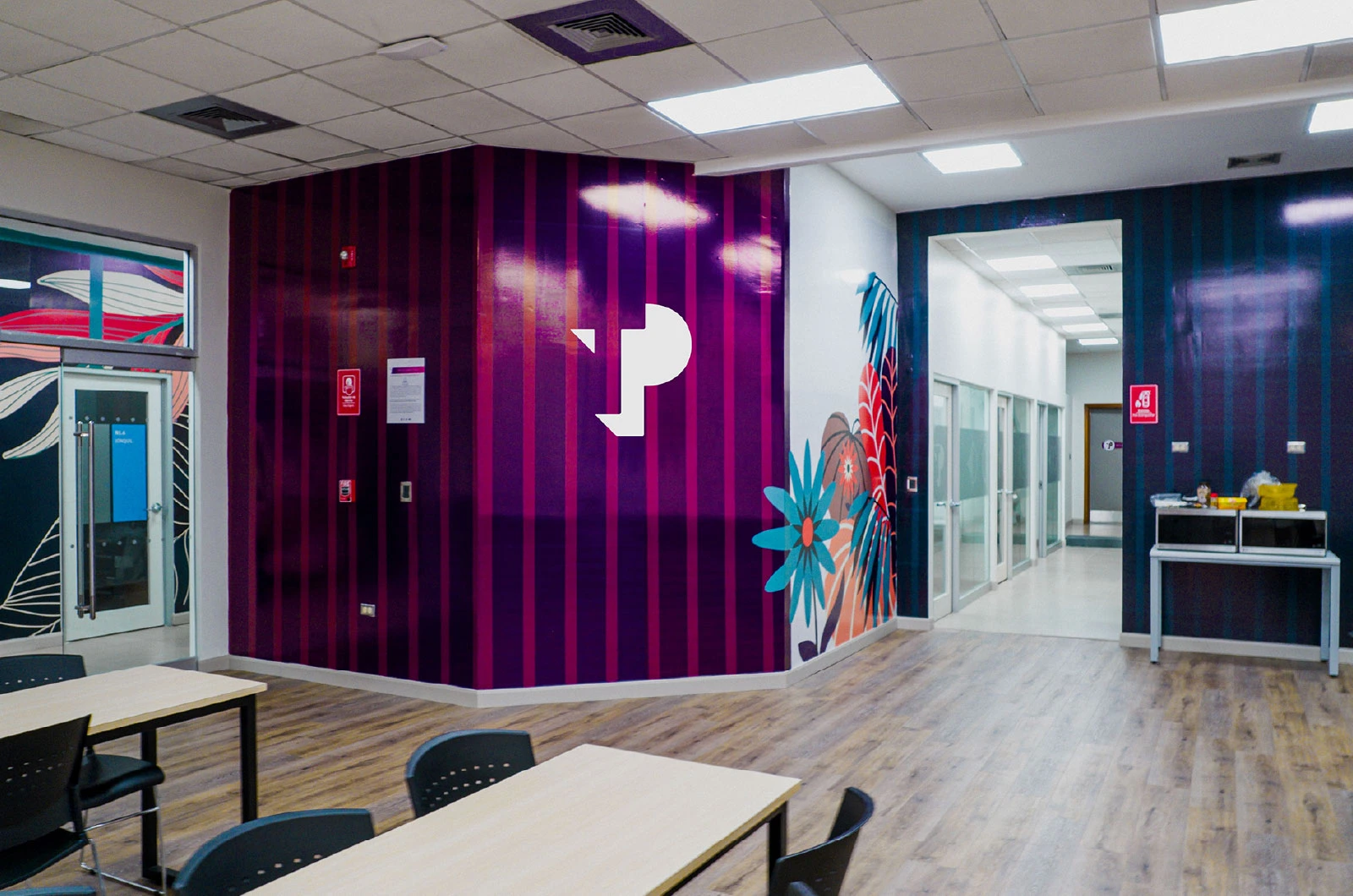 TP office space with purple striped walls, floral mural, and seating area.