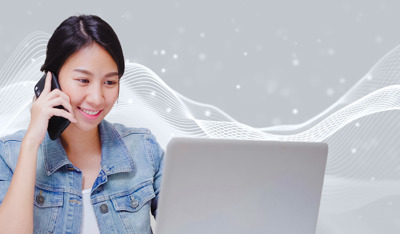 Smiling lady talks on phone while checking laptop amid digital sound waves.