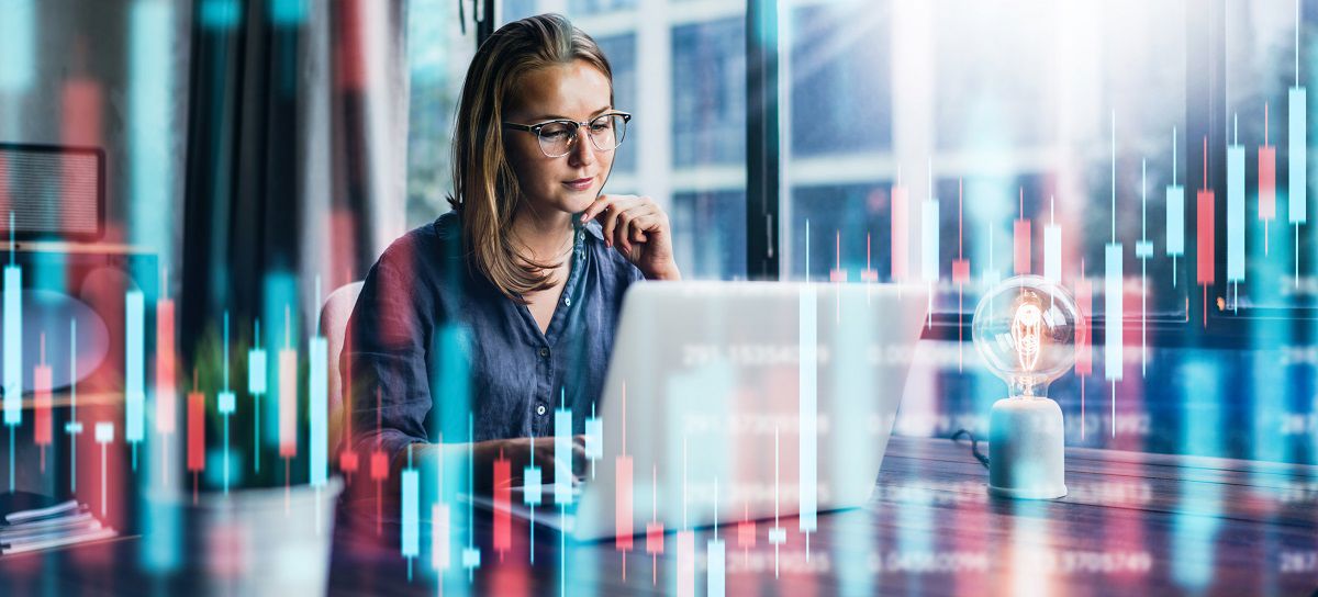Focused business woman working on her laptop with 3D candlestick graph elements